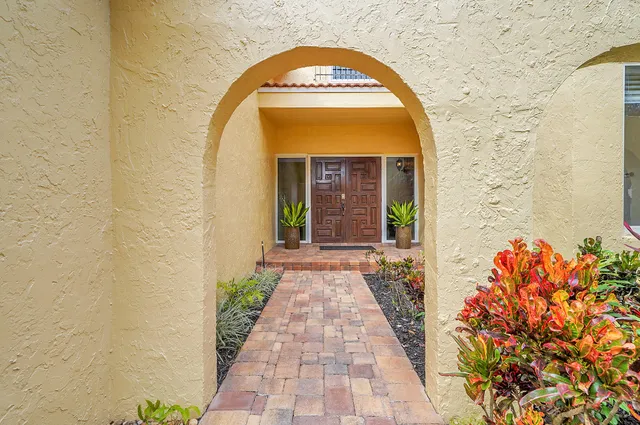 a view of a brick house with potted plants