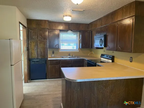 a kitchen with stainless steel appliances a refrigerator a sink and a stove