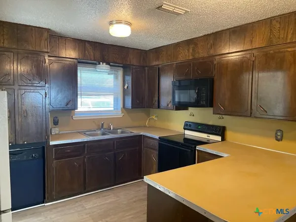 a kitchen with stainless steel appliances granite countertop a sink a stove and a refrigerator