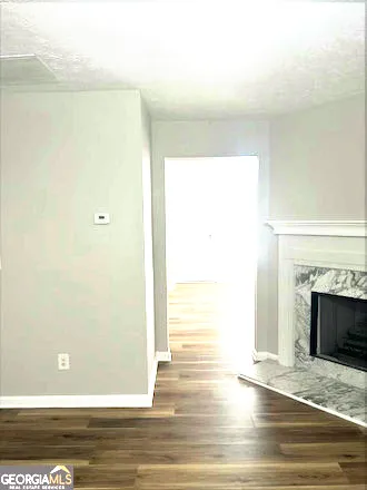 a view of empty room with wooden floor and fireplace