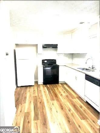 a kitchen with granite countertop white cabinets and stainless steel appliances