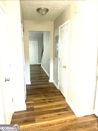 a view of a hallway with wooden floor and staircase