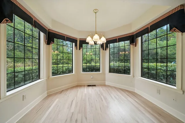 a view of empty room with wooden floor and city view