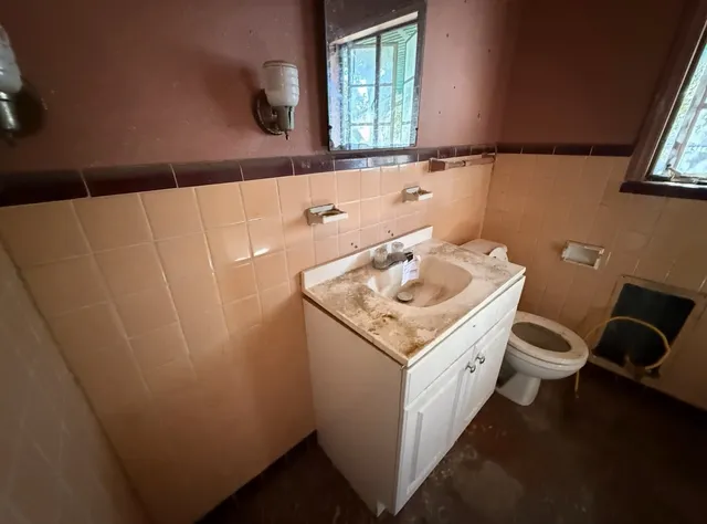 a bathroom with a sink a toilet and a window