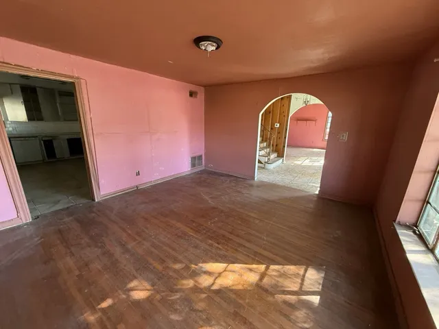 a view of a livingroom with wooden floor and entryway