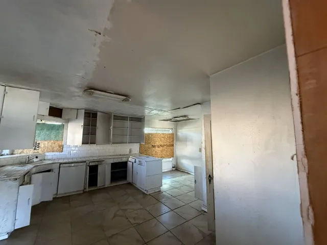 a view of a kitchen with a sink and a refrigerator