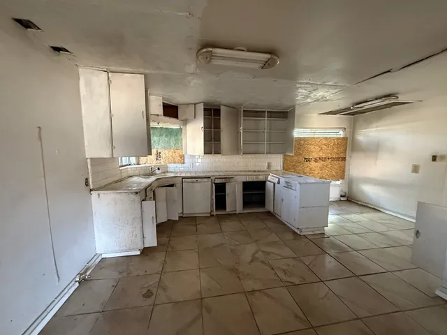 a kitchen with a sink a stove and cabinets