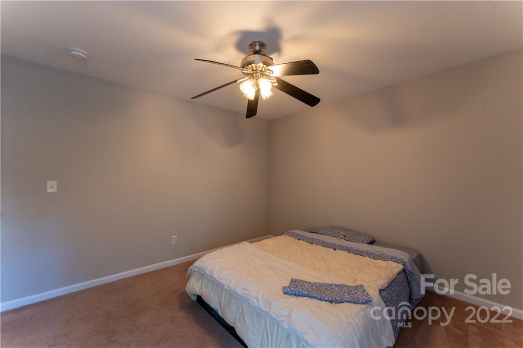 3106 Tanzanite Circle Fort Mill, SC 29708 - Photo 28 of 36 a bedroom with a bed and a chandelier