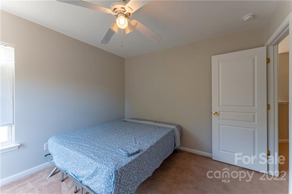 3106 Tanzanite Circle Fort Mill, SC 29708 - Photo 31 of 36 a bedroom with a bed and a chandelier