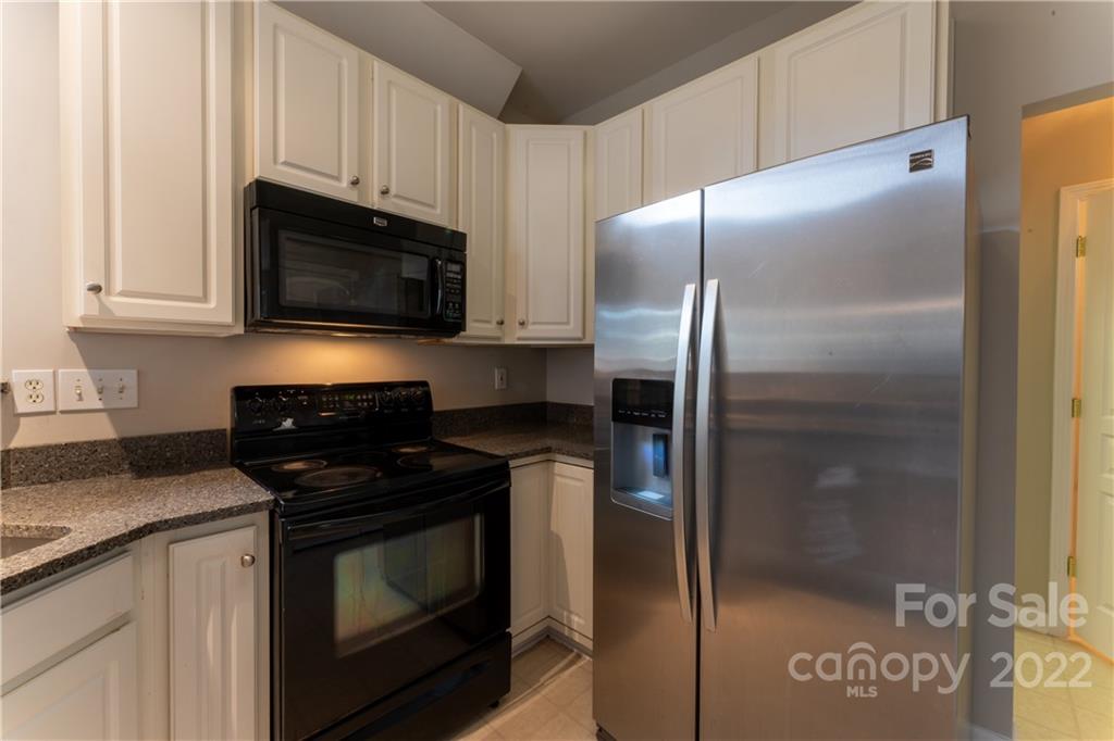 3106 Tanzanite Circle Fort Mill, SC 29708 - Photo 8 of 36 a kitchen with granite countertop a refrigerator stove and microwave