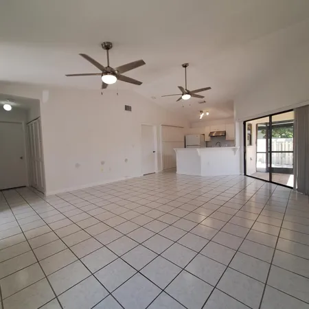a view of an empty room and window ceiling fan