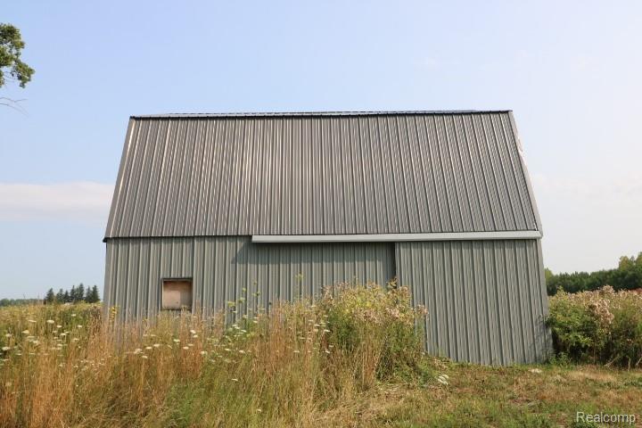 6577 East Deckerville Road Deford, MI 48729 - Photo 22 of 23 Metal-clad structure featuring a gambrel roof and sliding door