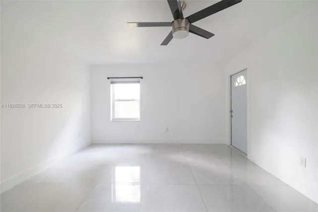 an empty room with windows and fan