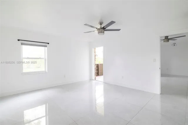 an empty room with a window and a ceiling fan