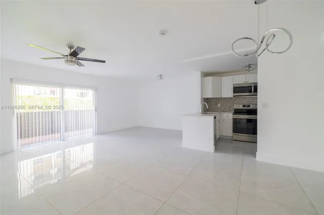 a kitchen with cabinets stainless steel appliances and a chandelier