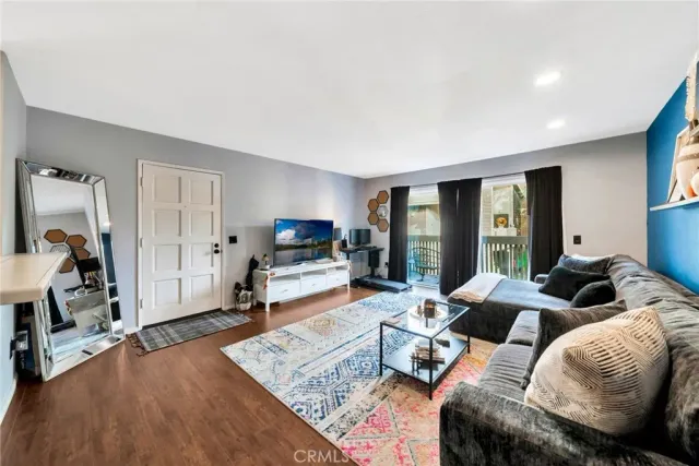 a living room with furniture and a wooden floor