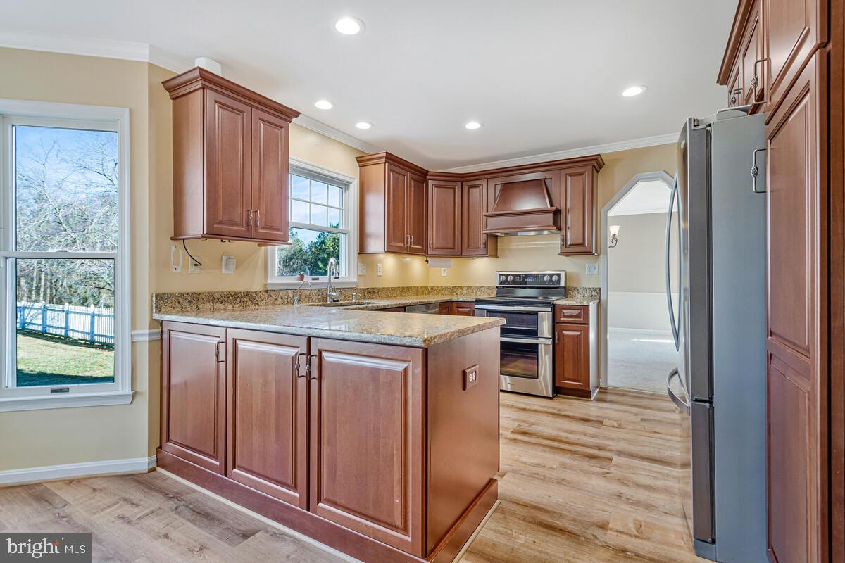 12630 Grosstown Road Hughesville, MD 20637 - Photo 15 of 44 a kitchen with stainless steel appliances granite countertop a refrigerator a sink dishwasher a stove and white countertops with wooden floor