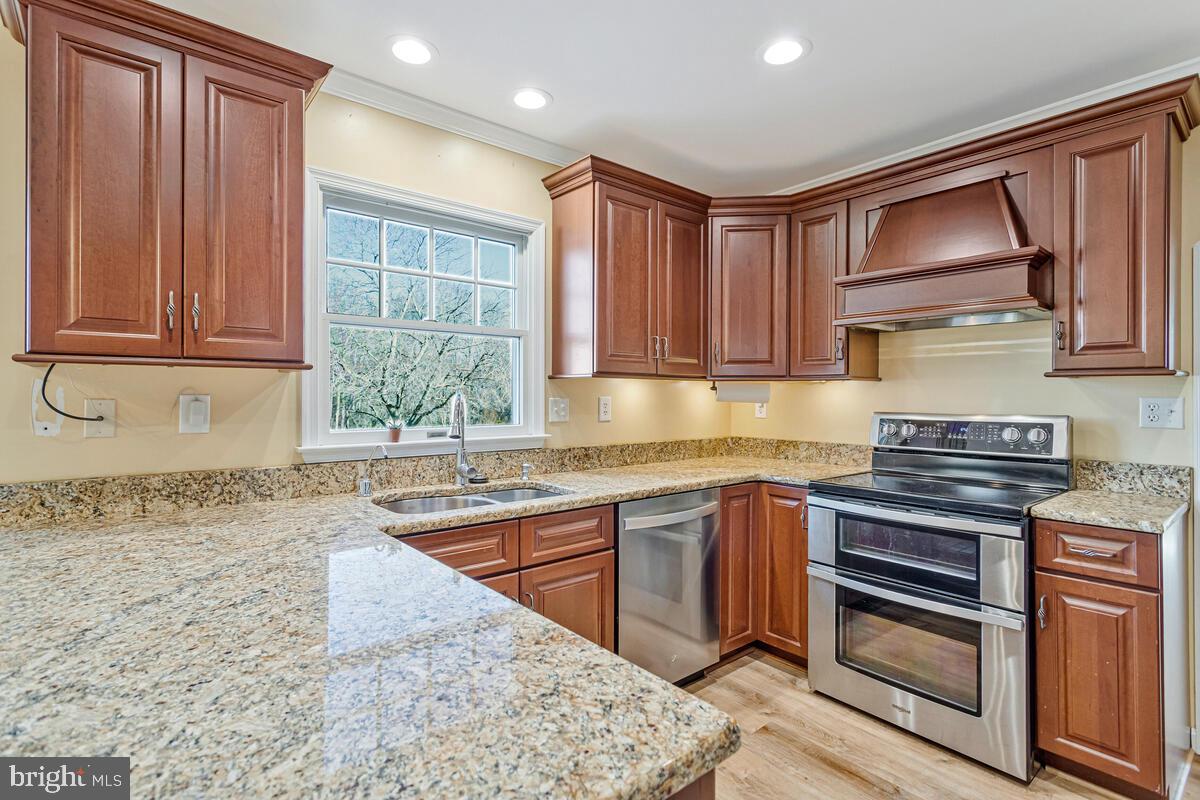 12630 Grosstown Road Hughesville, MD 20637 - Photo 16 of 44 a kitchen with stainless steel appliances granite countertop wooden cabinets a sink and a stove