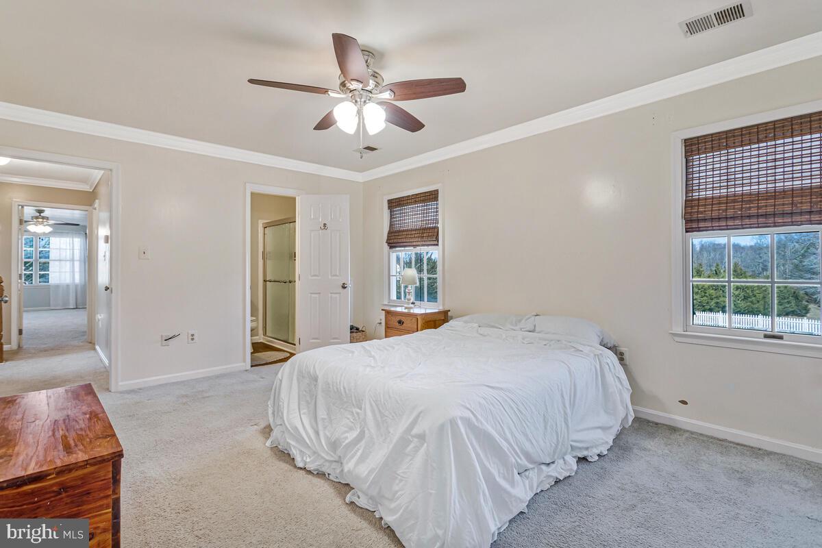 12630 Grosstown Road Hughesville, MD 20637 - Photo 24 of 44 a bedroom with a large bed and a chandelier