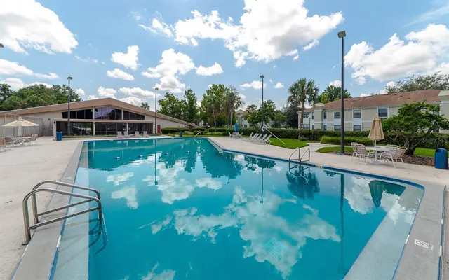 a view of a swimming pool with a yard in front of it