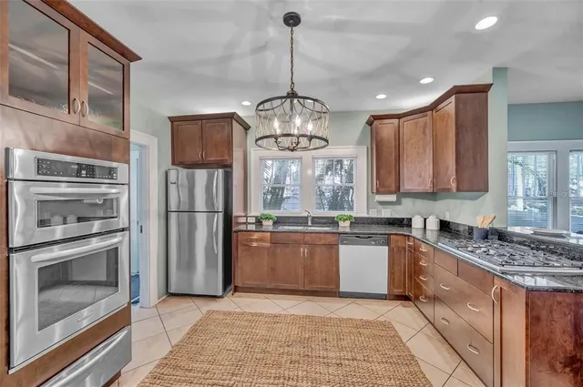 a kitchen with stainless steel appliances granite countertop a stove sink and refrigerator