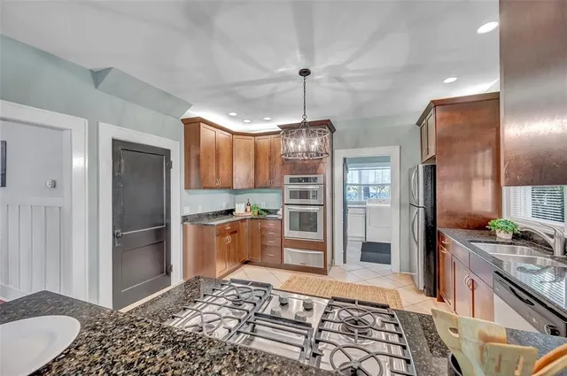 a kitchen with stainless steel appliances granite countertop a refrigerator and a stove top oven