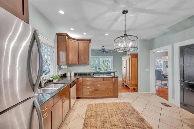 a large kitchen with stainless steel appliances granite countertop a sink refrigerator and cabinets