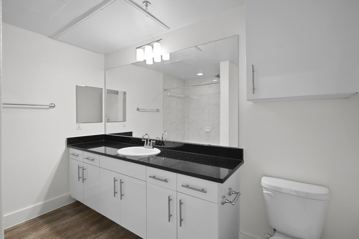 366 Fm 1488 Road, Unit 937 Conroe, TX 77384 - Photo 11 of 24 a bathroom with a granite countertop sink a toilet and a mirror