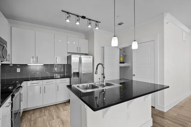 a kitchen with granite countertop a sink a stove and cabinets