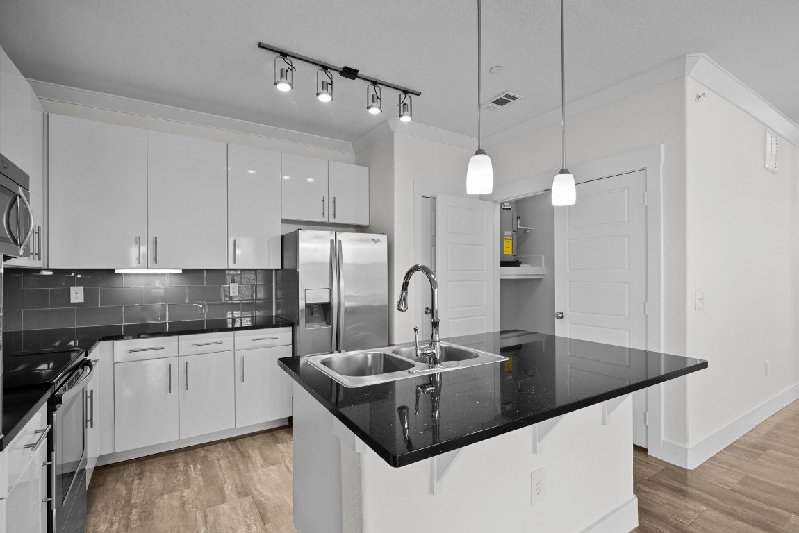 366 Fm 1488 Road, Unit 937 Conroe, TX 77384 - Photo 3 of 24 a kitchen with granite countertop a sink a stove and cabinets