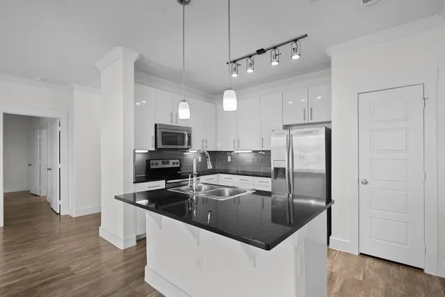 a kitchen with stainless steel appliances granite countertop a refrigerator a sink and a stove