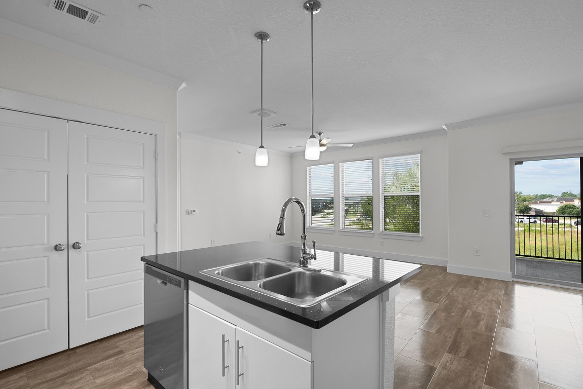 366 Fm 1488 Road, Unit 937 Conroe, TX 77384 - Photo 6 of 24 a kitchen with a sink a window and wooden floor