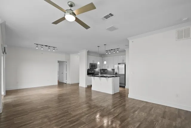 a large kitchen with cabinets wooden floor and stainless steel appliances