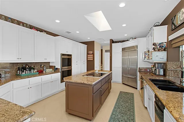 a kitchen with granite countertop a sink stove and refrigerator