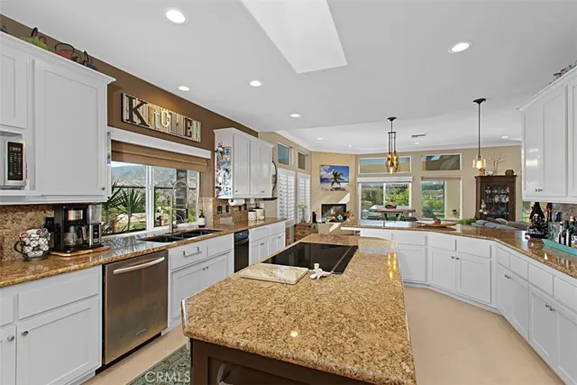 a kitchen with stainless steel appliances granite countertop sink stove and white cabinets