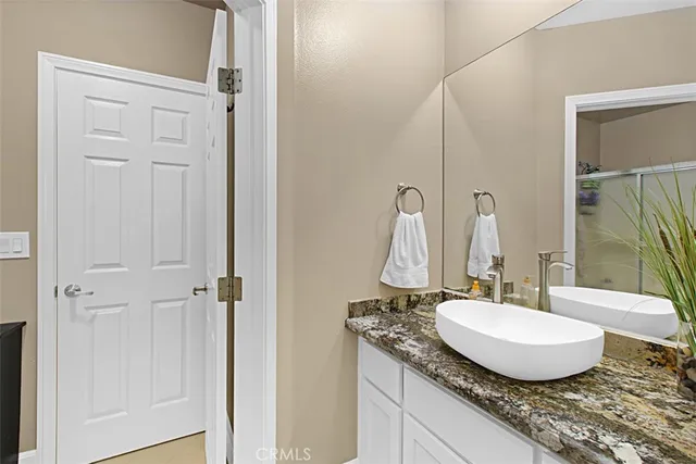 a bathroom with a granite countertop sink and a mirror