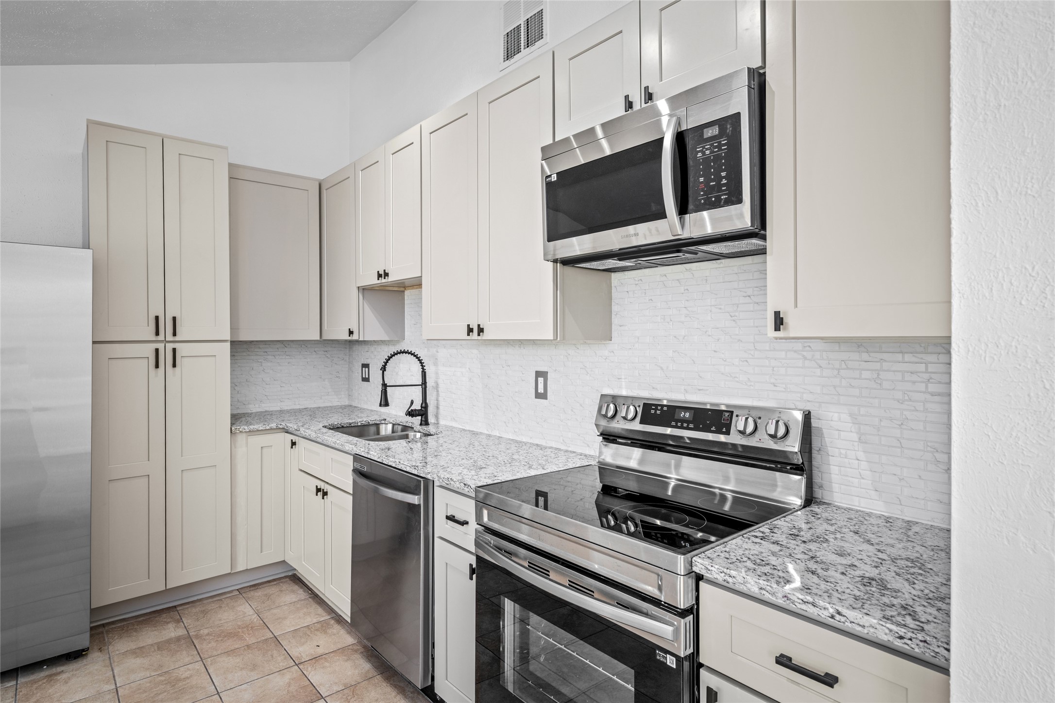 17510 Bullis Gap Drive Hockley, TX 77447 - Photo 13 of 21 a kitchen with stainless steel appliances a stove sink and microwave