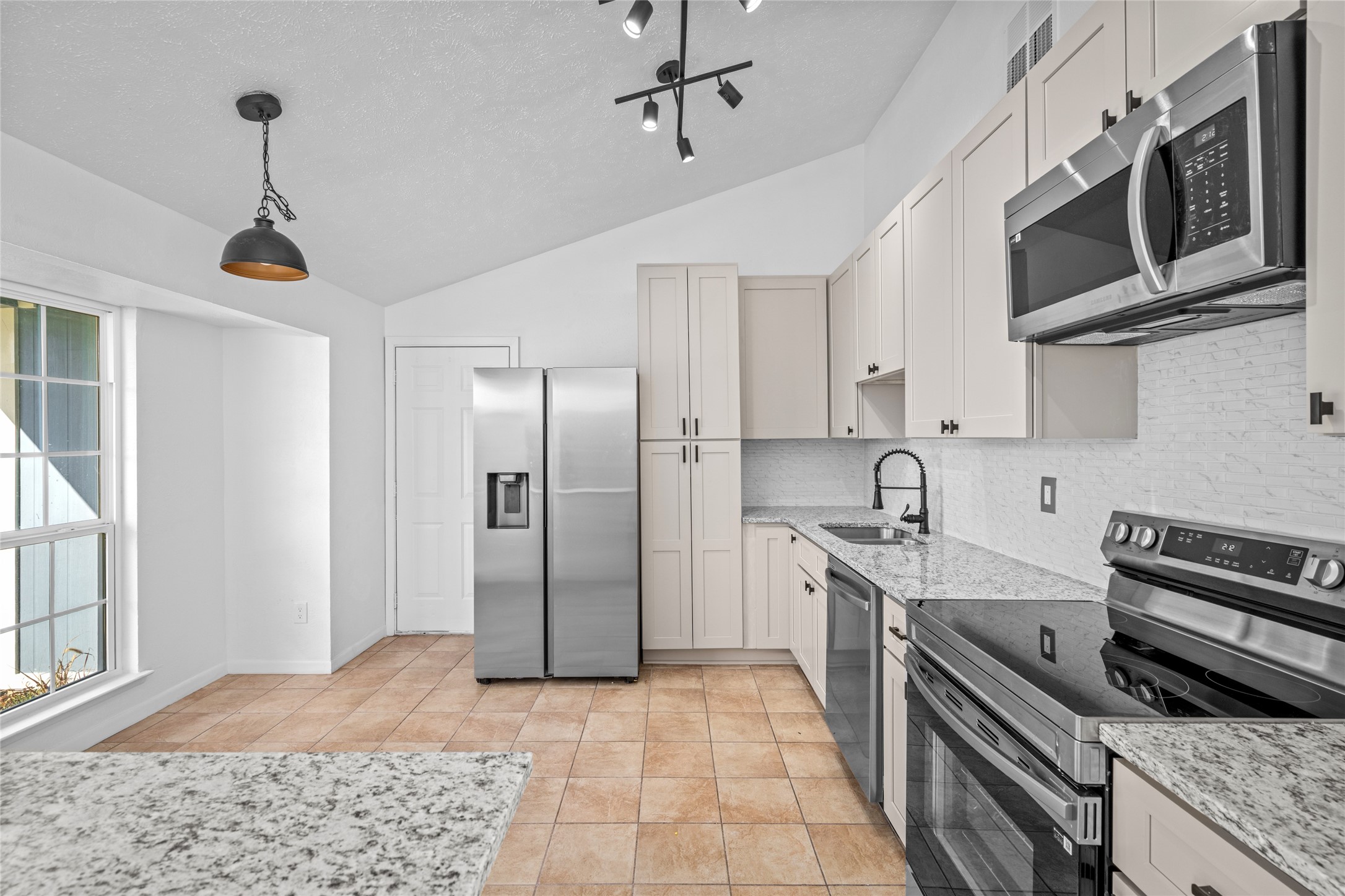 17510 Bullis Gap Drive Hockley, TX 77447 - Photo 14 of 21 a kitchen with stainless steel appliances granite countertop a sink a stove and a refrigerator