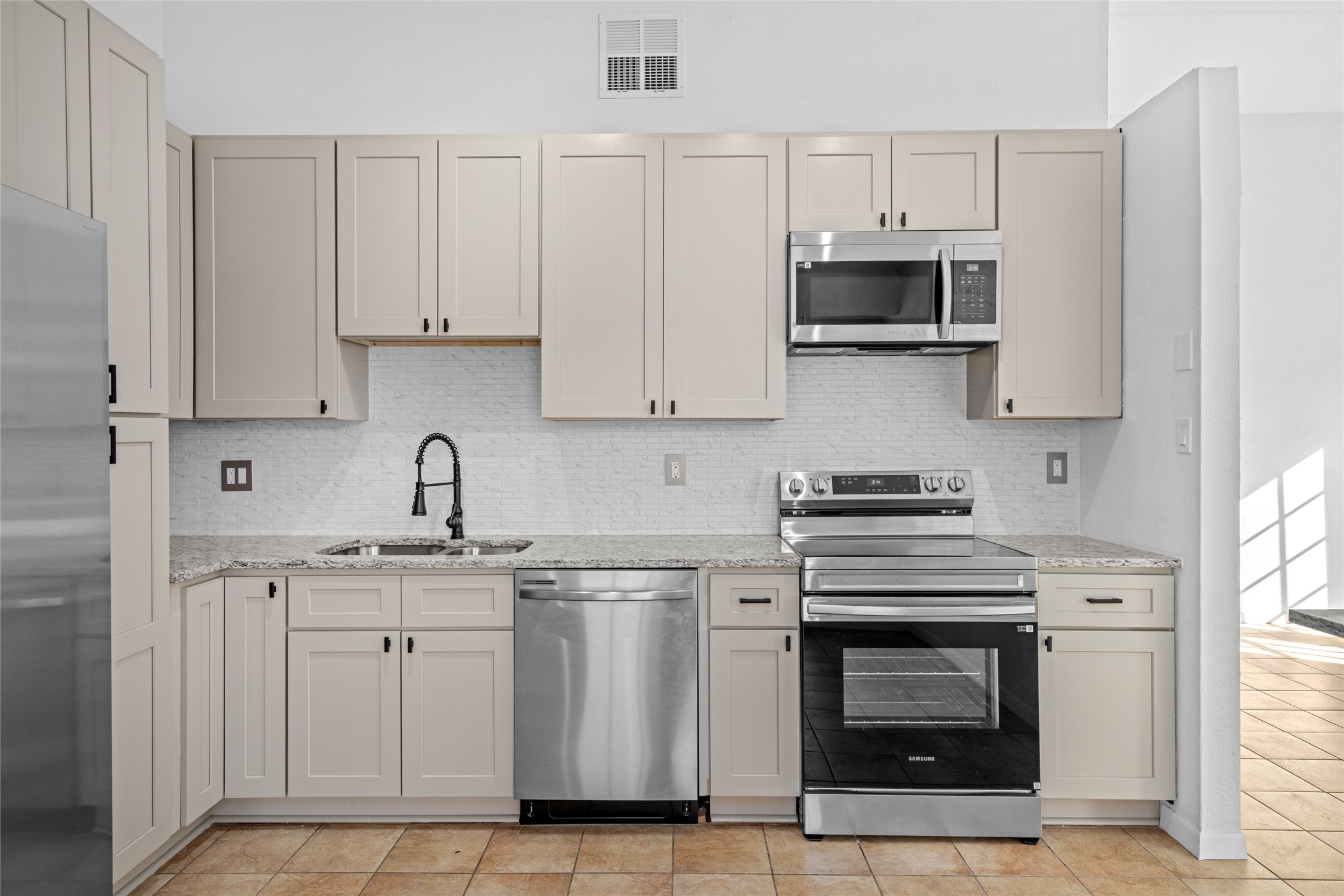 17510 Bullis Gap Drive Hockley, TX 77447 - Photo 3 of 21 a kitchen with stainless steel appliances granite countertop a stove a sink and a microwave