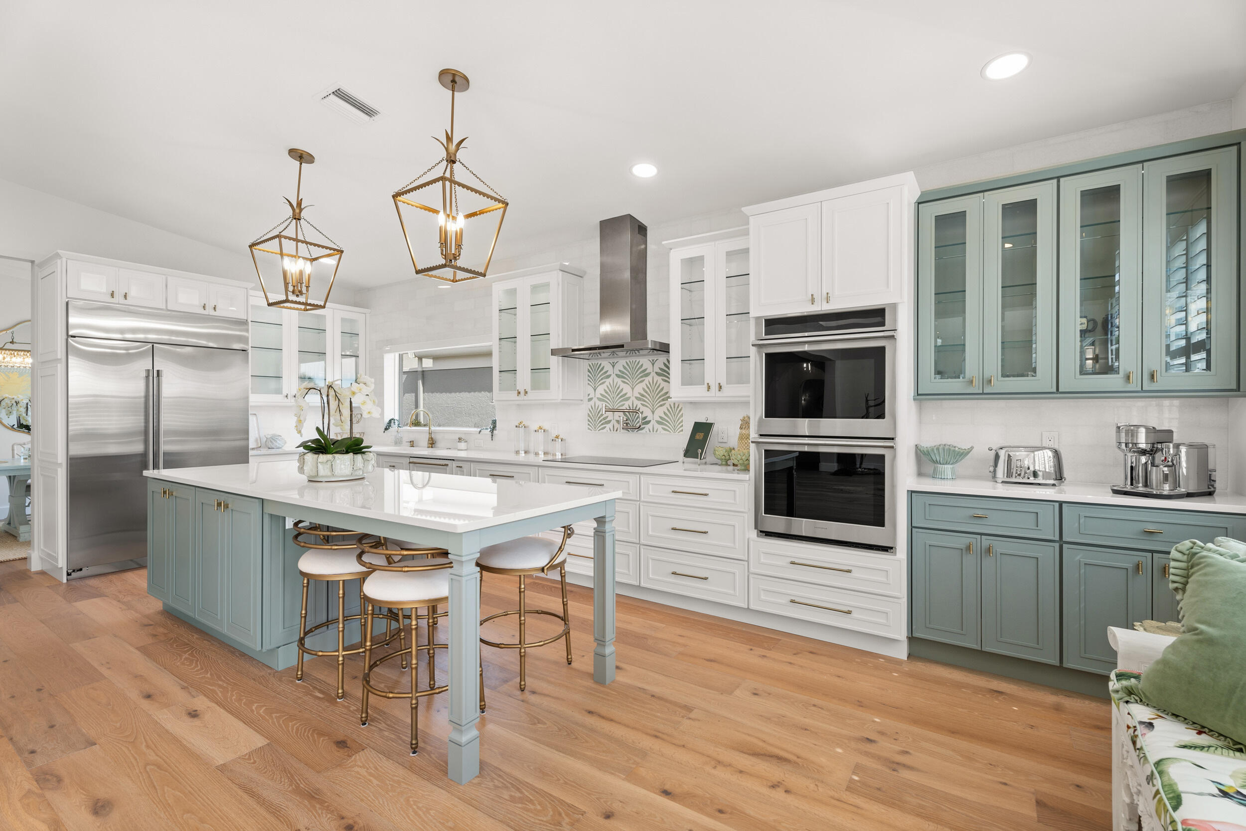 a kitchen with stainless steel appliances granite countertop a stove top oven a sink dishwasher and a refrigerator with wooden floor