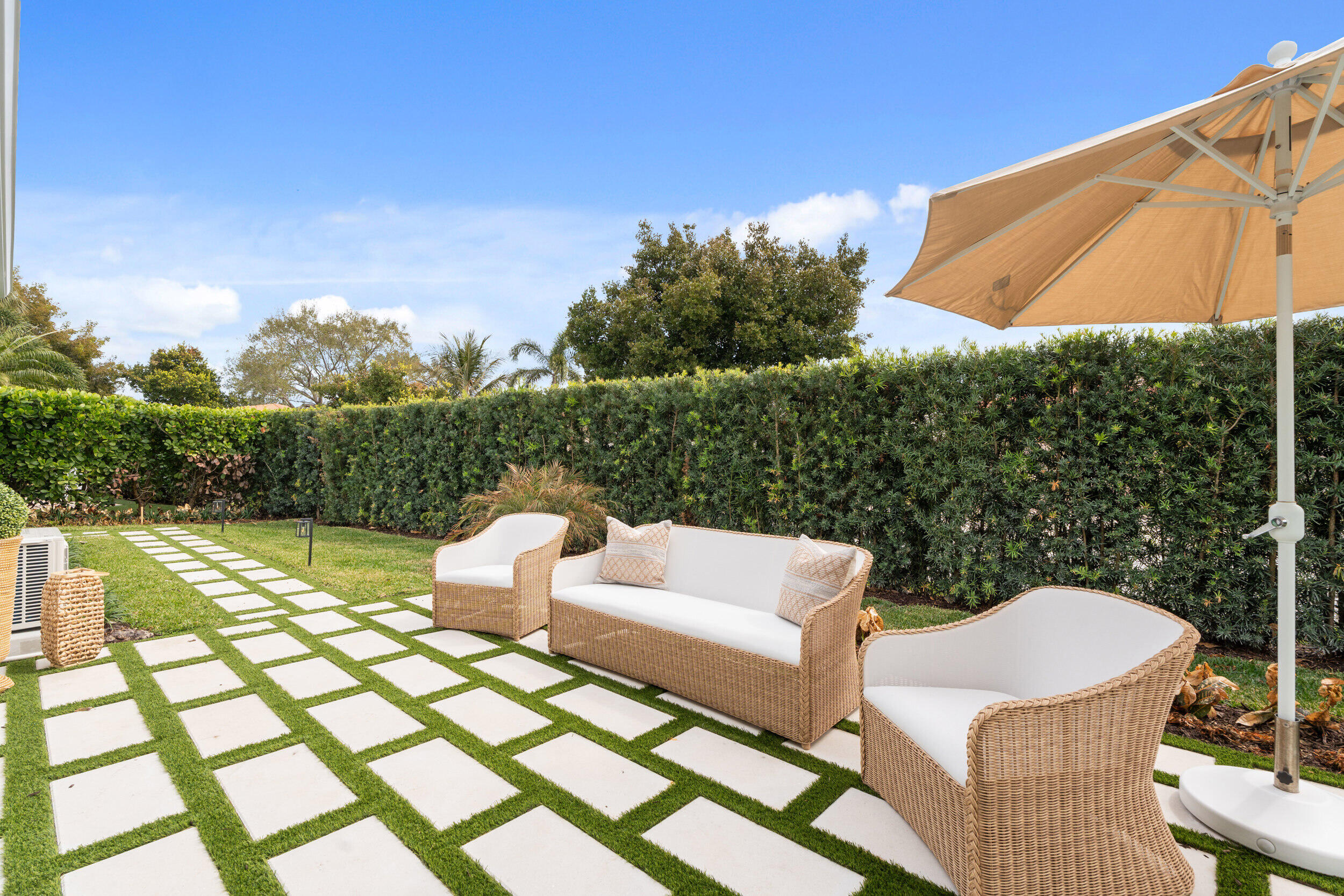 3660 Northwind Court Jupiter, FL 33477 - Photo 40 of 69 a view of a patio with couches table and chairs under an umbrella
