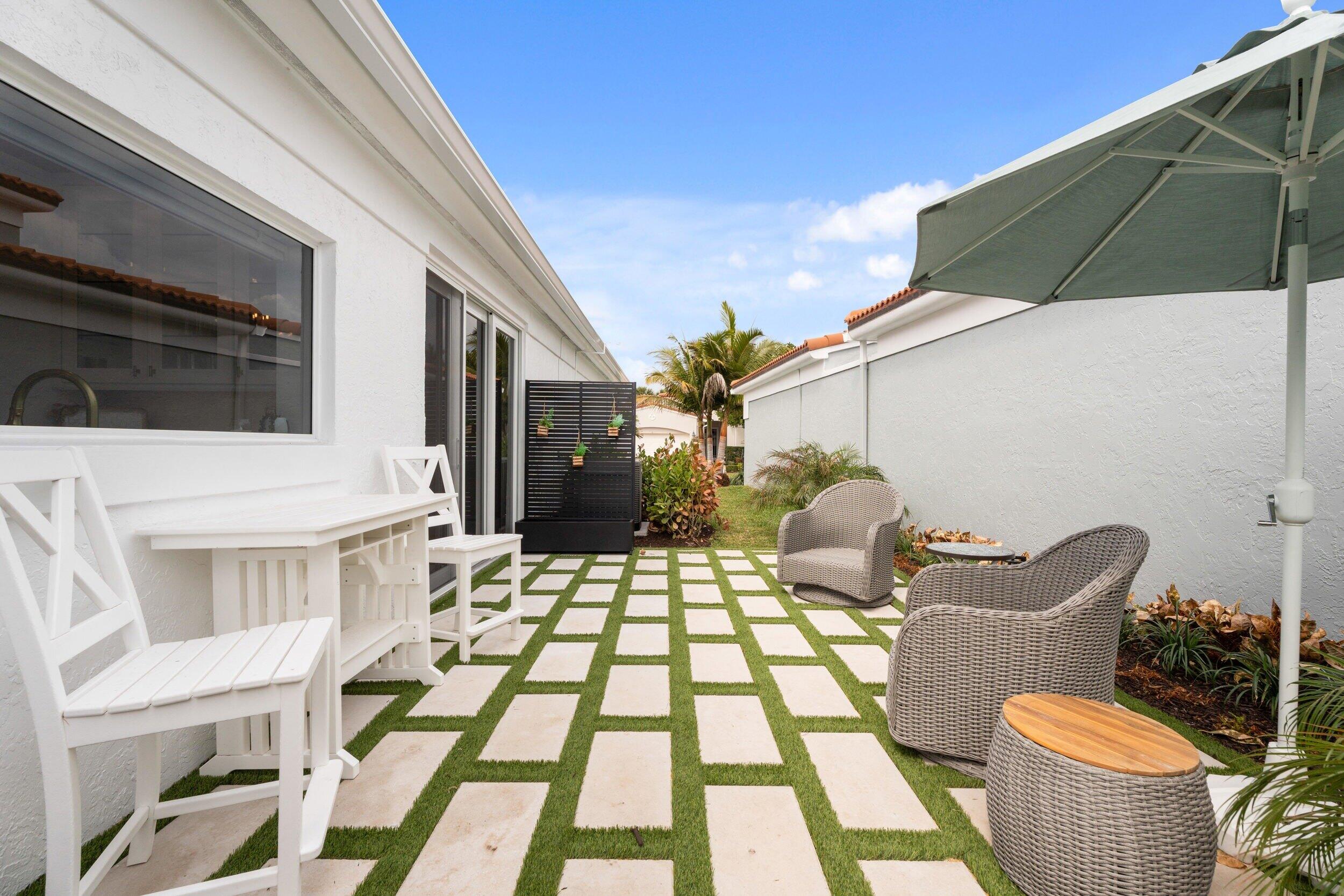 3660 Northwind Court Jupiter, FL 33477 - Photo 41 of 69 a view of a patio with a table and chairs