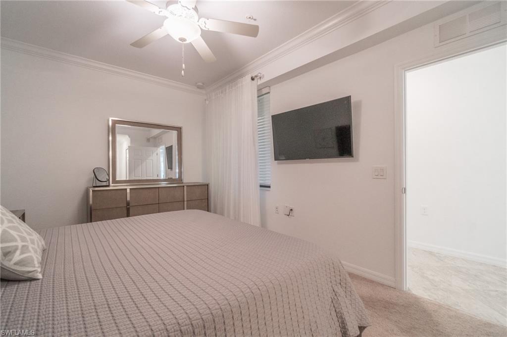 9596 Trevi Court, Unit 5426 Naples, FL 34113 - Photo 15 of 21 a bedroom with a bed and a flat screen tv