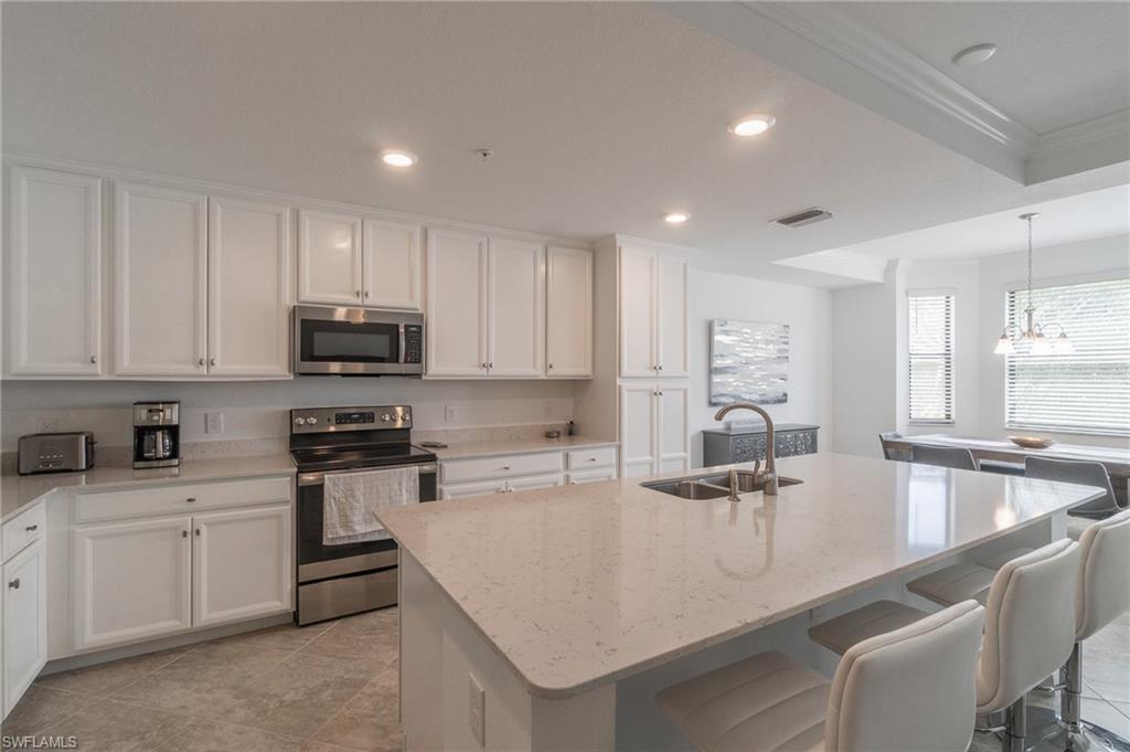 9596 Trevi Court, Unit 5426 Naples, FL 34113 - Photo 6 of 21 a kitchen with counter space cabinets and appliances