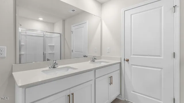 a bathroom with a double vanity sink and a mirror