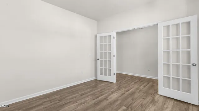 an empty room with wooden floor and empty shelves