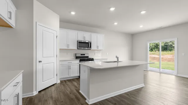 a kitchen with kitchen island granite countertop appliances cabinets and a sink