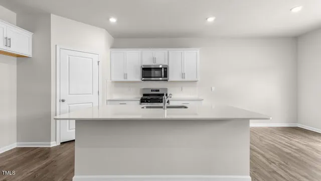 a kitchen with kitchen island a sink a stove and a refrigerator