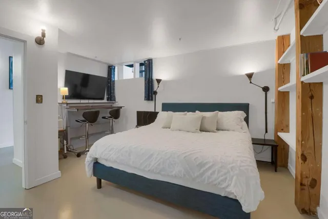 a bedroom with a bed and a flat tv screen on wall