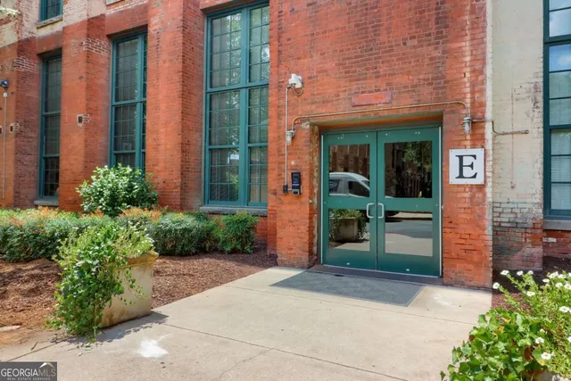 a view of a backyard with brick wall and potted plants